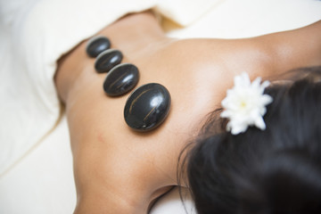 Obraz na płótnie Canvas massage with hot black stone by therapists