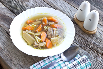 Beef and vegetable broth soup on wooden background