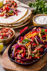Pork fajitas with onions and colored pepper, served with tortill