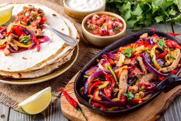 Pork fajitas with onions and colored pepper, served with tortill - obrazy, fototapety, plakaty