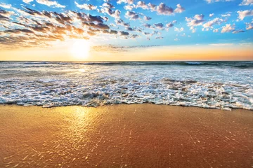 Photo sur Plexiglas Plage de Camps Bay, Le Cap, Afrique du Sud Lever de soleil coloré sur la plage de l& 39 océan avec un ciel bleu profond et des rayons de soleil.