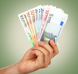 Hand with euro on green background