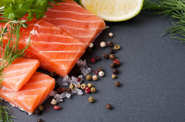Delicious portion of fresh salmon fillet with aromatic herbs, spices and vegetables - healthy food,...