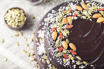 Vegan chocolate beet cake with avocado frosting, decorated nuts, seeds