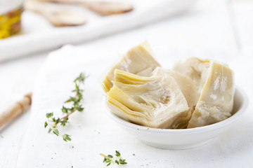 Artichoke hearts marinated in olive oil a small white bowl 