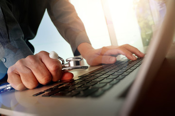 Doctor working at workspace with laptop computer in medical work