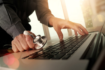 Doctor working at workspace with laptop computer in medical work