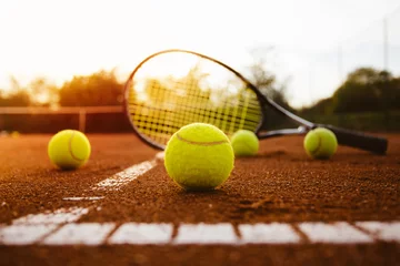 Zelfklevend Fotobehang Tennis balls with racket on clay court © yossarian6