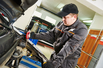 mechanic using a hydrometer to check the antifreeze