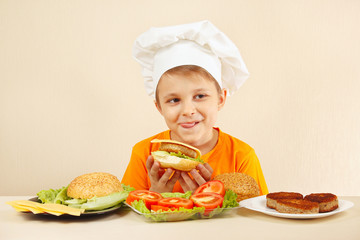 Little funny chef appetizing licked near the cooked hamburger