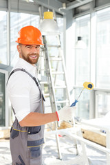 Handsome young painter is working at house