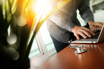 Doctor working at workspace with laptop computer in medical work