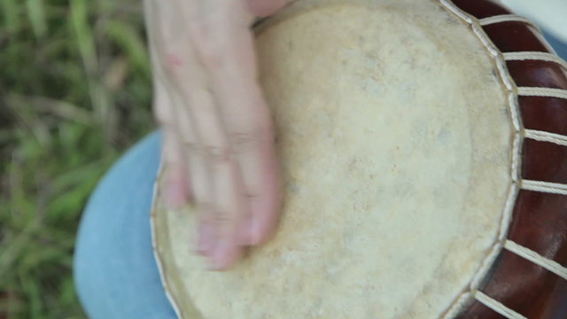 Women playing on Jambe Drum on nature