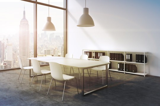 A conference room in a modern panoramic office with New York view. White table, white chairs, a bookcase and two white ceiling lights. 3D rendering. A sunset. Toned image.