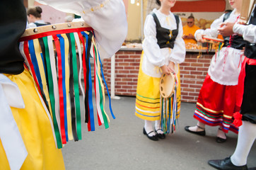 Fototapeta na wymiar Girl with a typical regional dress holding a colored tambourine during a folkloristic show 