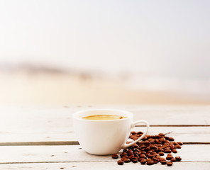 Cup of coffee on table on light background