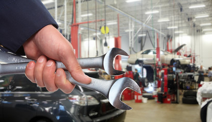   Hands of car mechanic in auto repair service. 