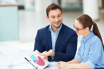 Two employees debating the chart.