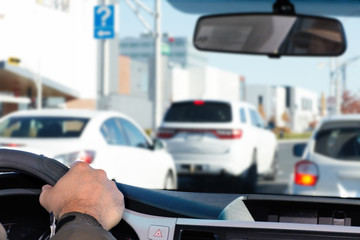 Hand of man driving on a highway.