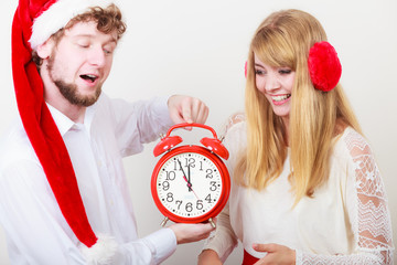 Happy couple woman and man with alarm clock.