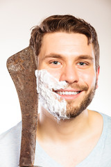 Young man shaving having fun with machete.