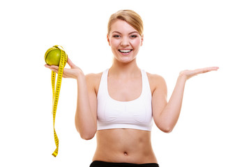 Joyful woman holds grapefruit and measurement tape