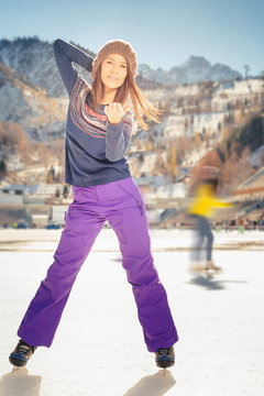 Pretty asian girl ice skating outdoor at ice rink