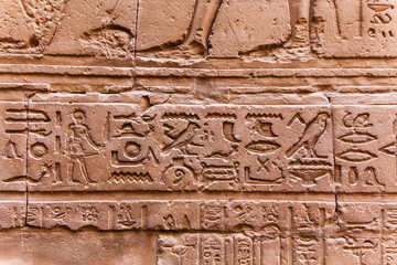 Egyptian hieroglyphics on the stone wall. Ancient stone carved E