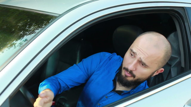 Young man with beard shouting and beeping in his passenger car