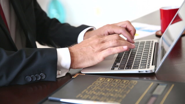Businessman using calculator and laptop computer