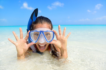 Beach vacation fun woman wearing a snorkel scuba mask making a goofy face while swimming in ocean...