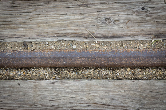 horizontal background image of an old wood surface with an iron railroad tie going through the middle great for text or copy space.