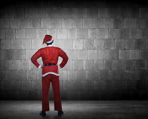 Man in santa claus costume looking at the wall
