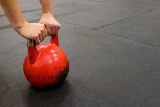 Close-up Of Woman’s Hands On A Red Kettle Bell 
