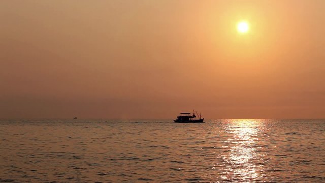 Tourist boat backlit sailing at sea, gulf of Thailand; hd 1080 static frame; 