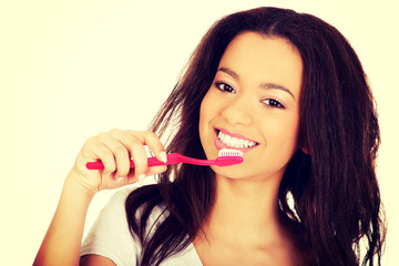 Beautiful teen brushing her teeth.