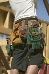 Tool belt of carpenter working on the framing process of home construction in Southern California