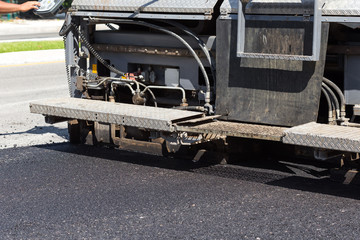 Pavement truck laying fresh asphalt