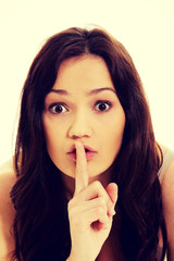 Naklejka premium Young woman with finger on lips.