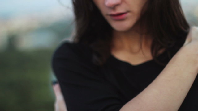 Woman hugging her arms in windy weather