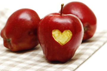 Apples with heart and on the napkin isolated on white