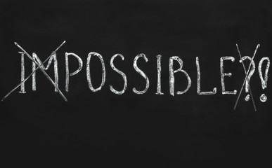 Obraz premium Impossible written with white chalk on a blackboard