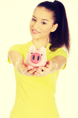 Happy woman holding piggybank.