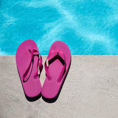 Fototapeta na wymiar Pink slippers near swimming pool