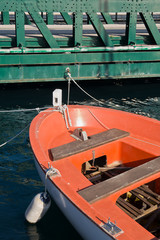 Fototapeta na wymiar orange boat and green bridge,orange boat tied to the iron green bridge
