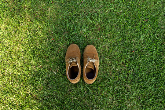 Old Shoes Over The Grass Field