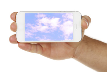 Hand holding mobile smart phone with sky in screen. Cloud computing concept