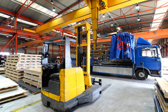 Gabelstapler/ Hubwagen und LKW zur Verladung in einer Industriehalle // Forklift and truck in industrial hall