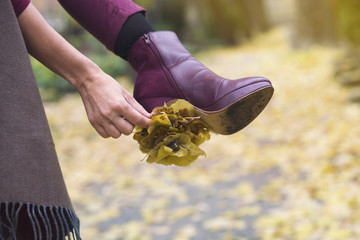 closeup of woman's shoe with leaves stuck on her heal