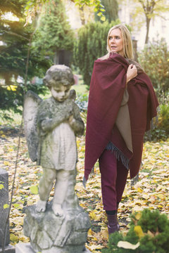 woman next to a grave with an angel